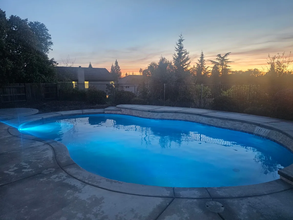 Pool Decks detail — Freeform pool blue led lighting dusk by Pinnacle Pools and Landscape, Sacramento CA