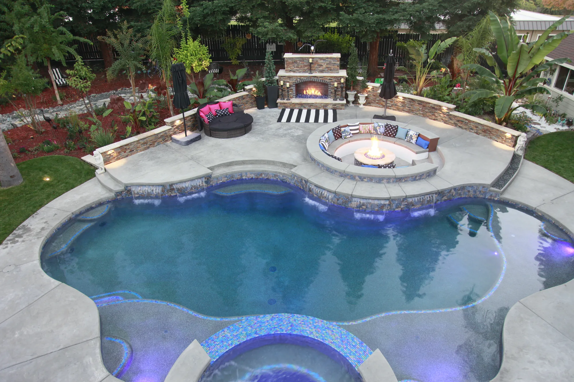 Freeform pool with fire pit and fireplace backyard by Pinnacle Pools and Landscape