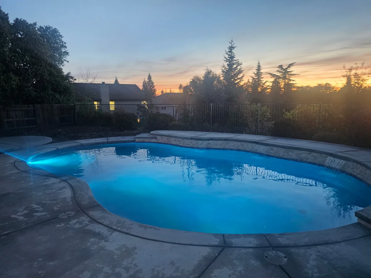 Freeform pool led lighting sunset by Pinnacle Pools and Landscape, Sacramento CA