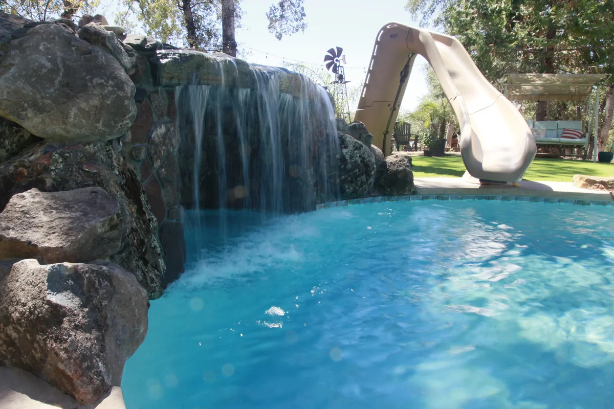 Rock waterfall pool slide by Pinnacle Pools and Landscape, Sacramento CA